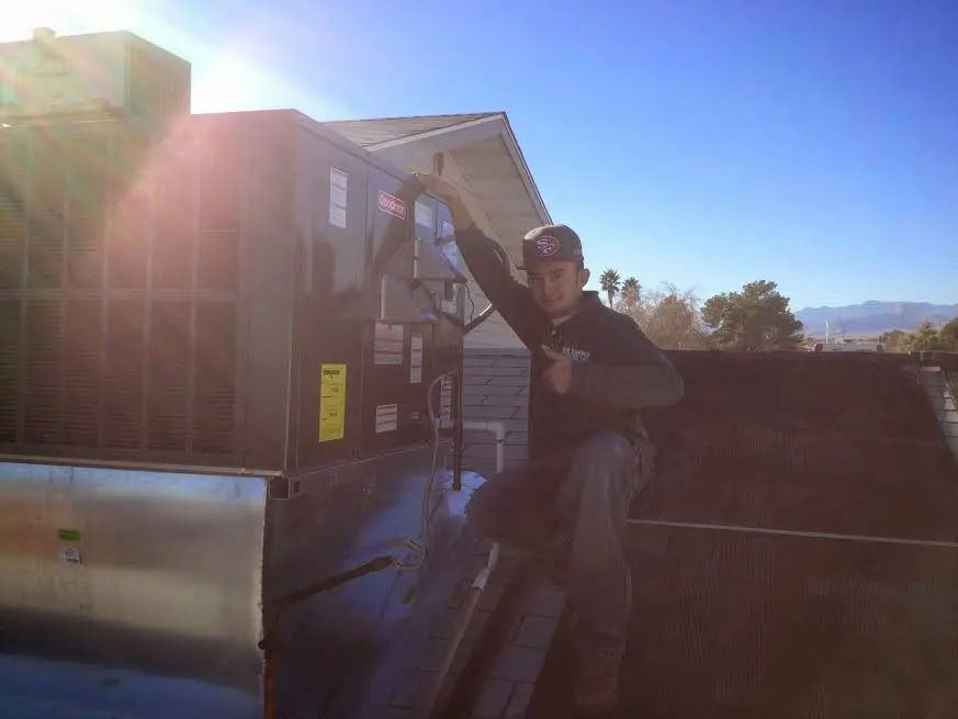 HVAC technician performing HVAC Inspection on a rooftop unit in Gladeview